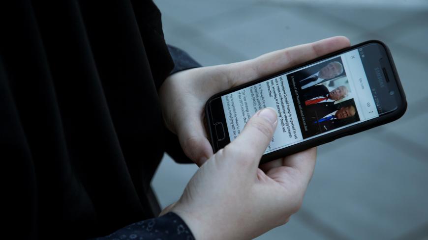 A woman displays pictures of U.S. President Donald Trump as she follows the news on her mobile phone in Tehran, Iran October 13, 2017. Nazanin Tabatabaee Yazdi/TIMA via REUTERS ATTENTION EDITORS - THIS IMAGE WAS PROVIDED BY A THIRD PARTY. - RC199832B120