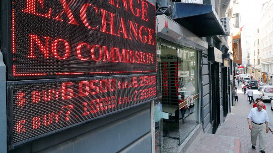 A man walks past by a board showing the currency exchange rates next to a currency exchange office in Istanbul, Turkey August 28, 2018. REUTERS/Osman Orsal - RC133EF73130
