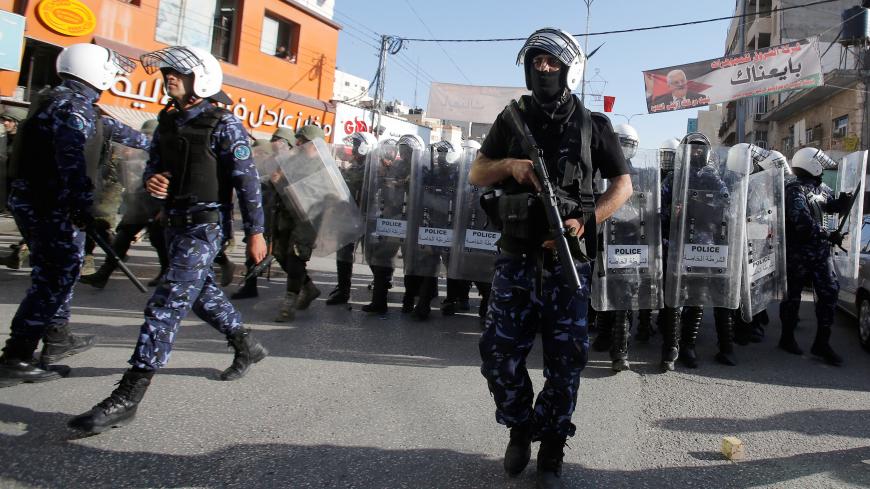 Members of Palestinian security forces stand guard during a protest organised by Hizb-ut Tahrir in Hebron, in the occupied West Bank, April 14, 2018. REUTERS/Mussa Qawasma - RC1C754DC650