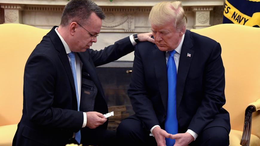 U.S. President Donald Trump closes his eyes in prayer along with Pastor Andrew Brunson, after his release from two years of Turkish detention, in the Oval Office of the White House, Washington, U.S., October 13, 2018. REUTERS/Mike Theiler     TPX IMAGES OF THE DAY - RC18ECD30AF0