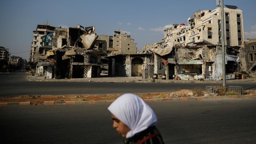 A woman walks past destroyed buildings in the government-controlled part of Homs, Syria, September 18, 2018. REUTERS/Marko Djurica     SEARCH "SYRIA LIFE" FOR THIS STORY. SEARCH "WIDER IMAGE" FOR ALL STORIES. TPX IMAGES OF THE DAY - RC1EE143EBF0