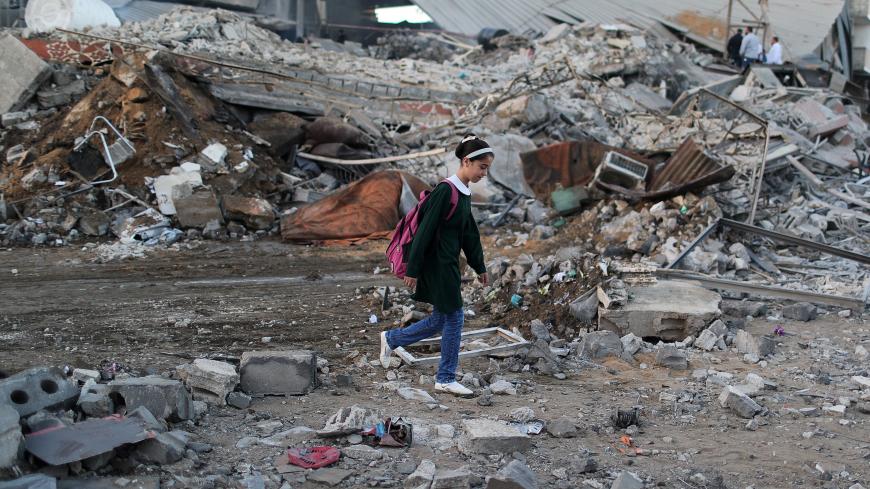 A Palestinian schoolgirl walks past the scene of an Israeli air strike on a building in Gaza City October 27, 2018. REUTERS/Mohammed Salem - RC1879C7A810