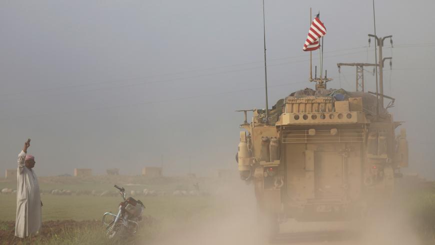A man gestures at U.S military vehicles driving in the town of Darbasiya next to the Turkish border, Syria April 28, 2017. REUTERS/Rodi Said TPX IMAGES OF THE DAY - RC15AC3FC730