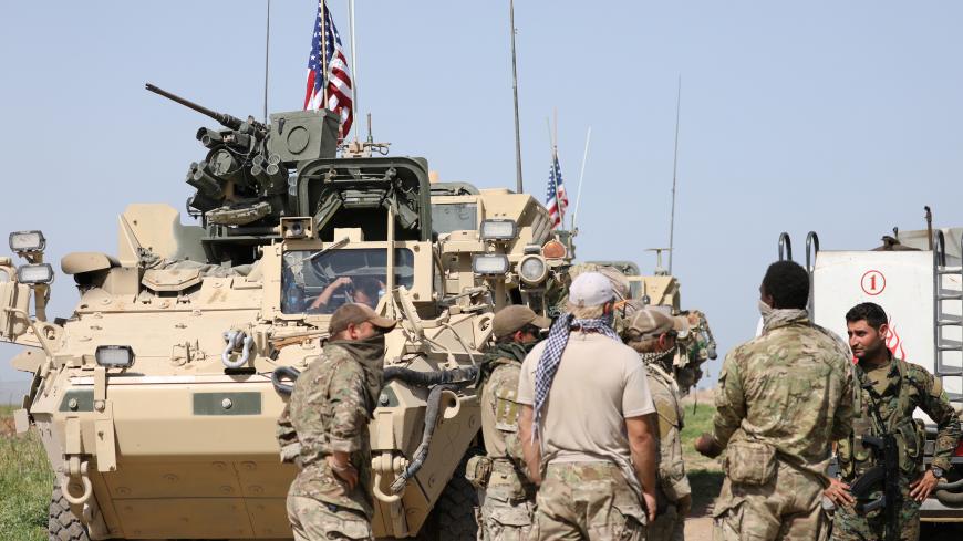 Kurdish fighters from the People's Protection Units (YPG) chat with members of U.S. forces in the town of Darbasiya next to the Turkish border, Syria April 29, 2017. Picture taken April 29, 2017. REUTERS/Rodi Said - RC16BE0EE700
