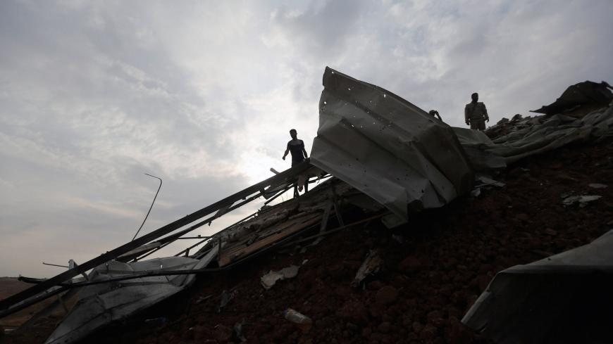 Palestinians survey the scene of an Israeli airstrike at a Hamas outpost in the central Gaza Strip October 9, 2017. REUTERS/Ibraheem Abu Mustafa - RC1FBD3435D0