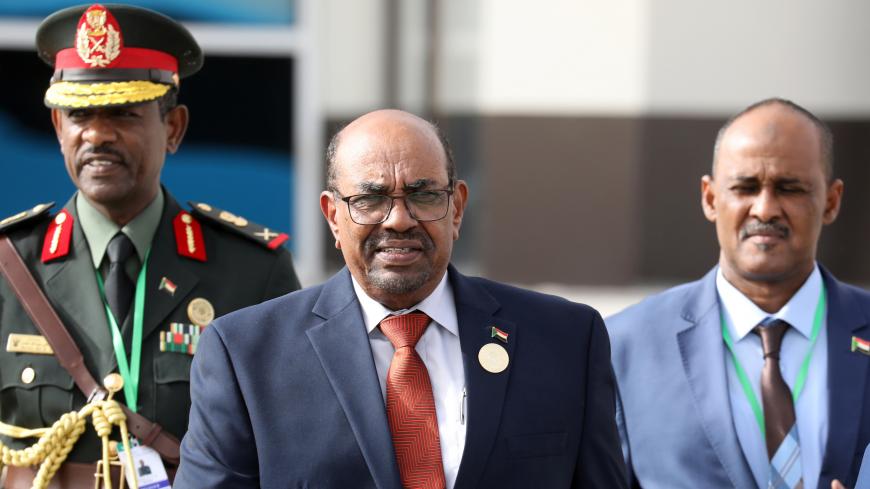 Sudan's President Omar al-Bashir walks with officials as he leaves the African Union (AU) summit in Nouakchott, Mauritania, July 2, 2018.  Ludovic Marin/Pool via Reuters - RC1D50433000
