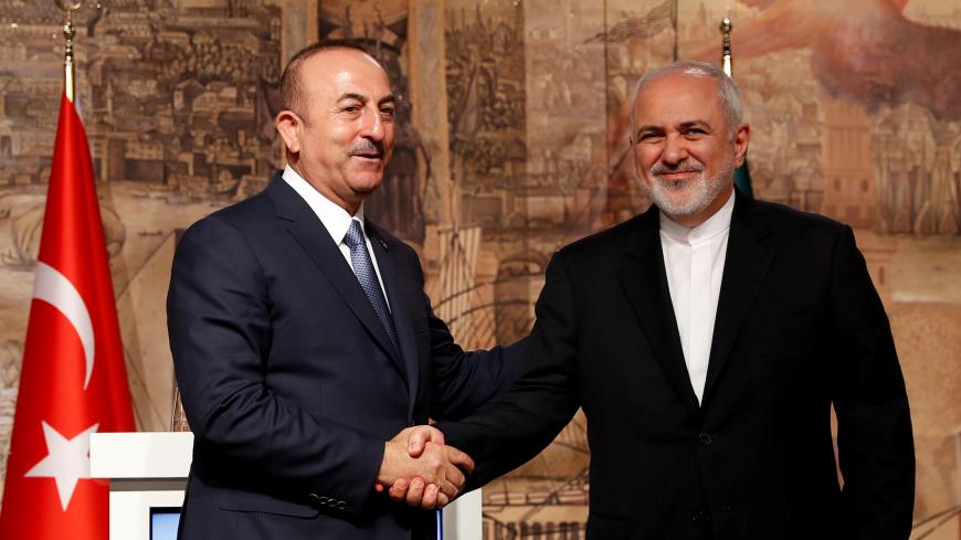 Turkish Foreign Minister Mevlut Cavusoglu shakes hands with his Iranian counterpart Javad Zarif during a news conference in Istanbul, Turkey October 30, 2018. REUTERS/Murad Sezer - RC15CF69EA60