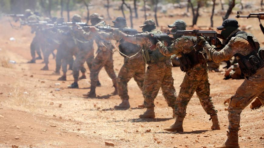 Syrian fighters fire AK-47 rifles as they attend a mock battle in anticipation of an attack by the regime on Idlib province and the surrounding countryside, during a graduation of new Hayat Tahrir al-Sham (HTS) members at a camp in the countryside of the northern Idlib province on August 14, 2018. (Photo by OMAR HAJ KADOUR / AFP)        (Photo credit should read OMAR HAJ KADOUR/AFP/Getty Images)