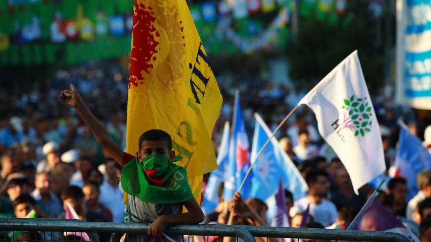 A young boy masked with a green flag gestures during a "World Peace Day" rally gathering supporters of Turkey's main pro-Kurdish Peoples' Democratic Party (HDP) in Diyarbakir, on September 1, 2018. (Photo by STR / AFP)        (Photo credit should read STR/AFP/Getty Images)