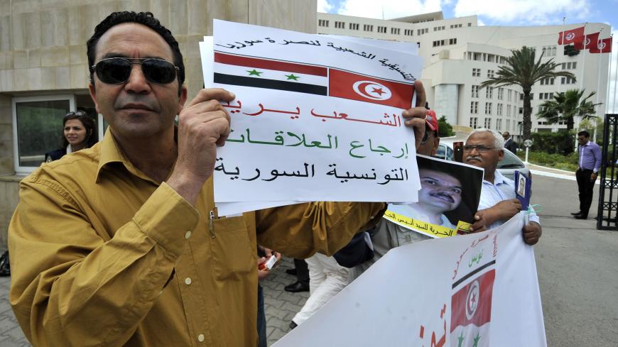 Tunisian protestors demonstrate outside the Ministry of Foreign Affairs on May 28, 2013 in Tunis, calling on their Islamist-led government to renew diplomatic relations with Syria and the regime of Bashar al-Assad. AFP PHOTO / FETHI BELAID        (Photo credit should read FETHI BELAID/AFP/Getty Images)