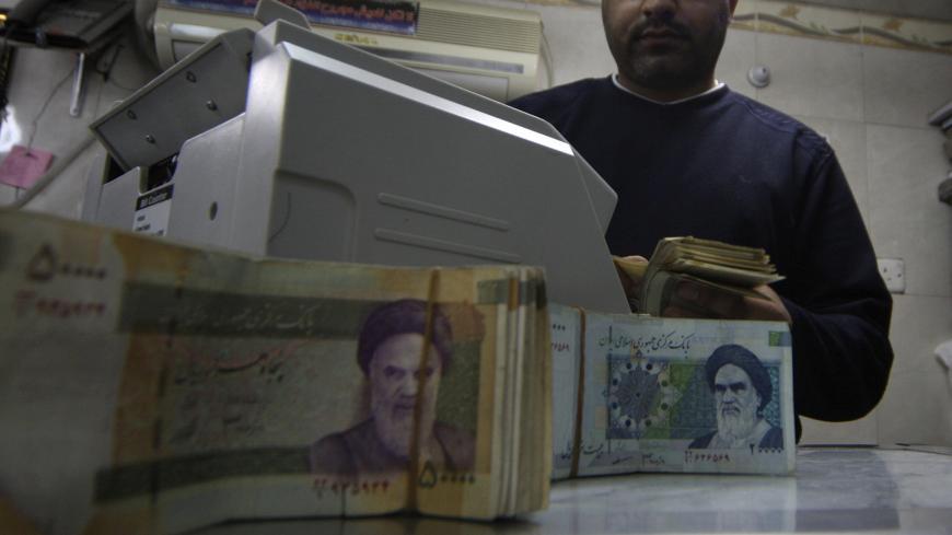 A man counts stacks of Iranian rials at a currency exchange shop in Kerbala , 110 km (70 miles) south of Baghdad January 23, 2013. Traders and owners of hotels in the holy city of Kerbala complain of sluggish business and a drop in Iranian pilgrims as a result of a sharp fall in the Iranian rial caused by a package of international sanctions imposed on the neighbouring country. REUTERS/Mushtaq Muhammed (IRAQ - Tags: SOCIETY BUSINESS) - GM1E91N1RPN01