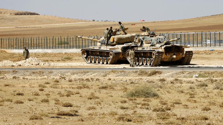 Turkish soldiers stand on top of tanks next to the Syrian-Trukish border fence near the town of Suruc in Sanliurfa province September 23, 2014. Some 138,000 Syrian Kurdish refugees have entered Turkey in an exodus that began last week, and two border crossing points remain open, the U.N. High Commissioner for Refugees said. REUTERS/Murad Sezer (TURKEY - Tags: POLITICS SOCIETY IMMIGRATION CONFLICT MILITARY) - LR1EA9N0VR52V
