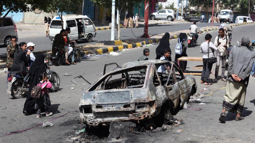 Onlookers look at a car burnt down by a blast in the war-torn southwestern city of Taiz, Yemen January 22, 2019. REUTERS/Anees Mahyoub - RC1FAD2F1FA0