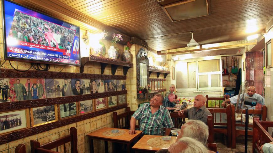 Iraqis watch the news on TV at a cafe on August 9, 2015 on al-Rasheed street in the capital Baghdad as Iraqi Prime Minister Haider al-Abadi called for sweeping reforms, including abolishing the current post of his predecessor Nuri al-Maliki, in response to weeks of demonstrations against corruption and poor services.  AFP PHOTO / SABAH ARAR        (Photo credit should read SABAH ARAR/AFP/Getty Images)