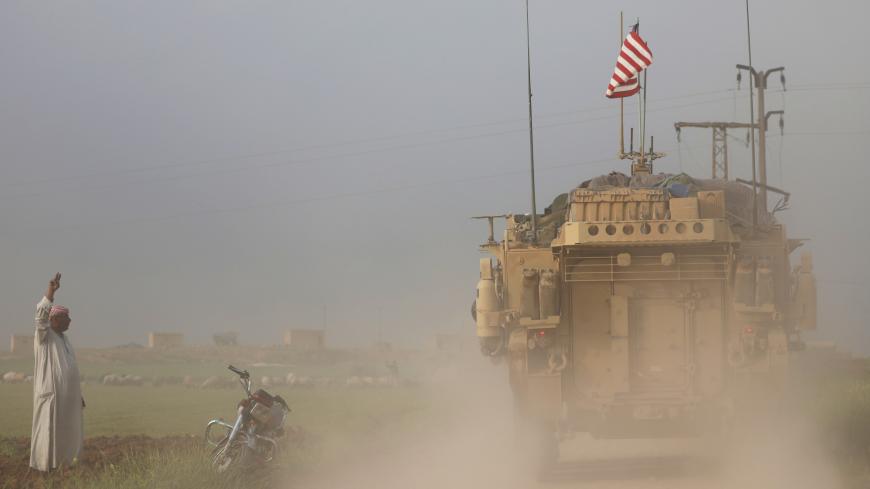 A man gestures at U.S military vehicles driving in the town of Darbasiya next to the Turkish border, Syria April 28, 2017. REUTERS/Rodi Said     TPX IMAGES OF THE DAY - RC15AC3FC730