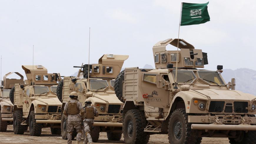 Saudi troops walk past armoured personnel carriers at their base in Yemen's southern port city of Aden September 28, 2015. REUTERS/Faisal Al Nasser  - GF10000225427