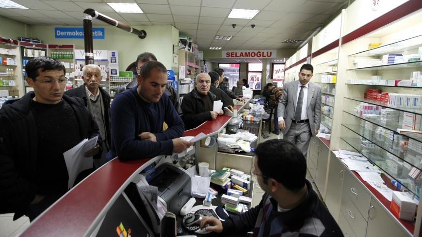 People shop in a pharmacy that did not participate in a  protest in Ankara December 4, 2009. Pharmacies shut down all over Turkey on Friday for one day to protest price discounts on drugs enforced by the government. REUTERS/Umit Bektas (TURKEY POLITICS HEALTH CONFLICT) - GM1E5C41P5H01