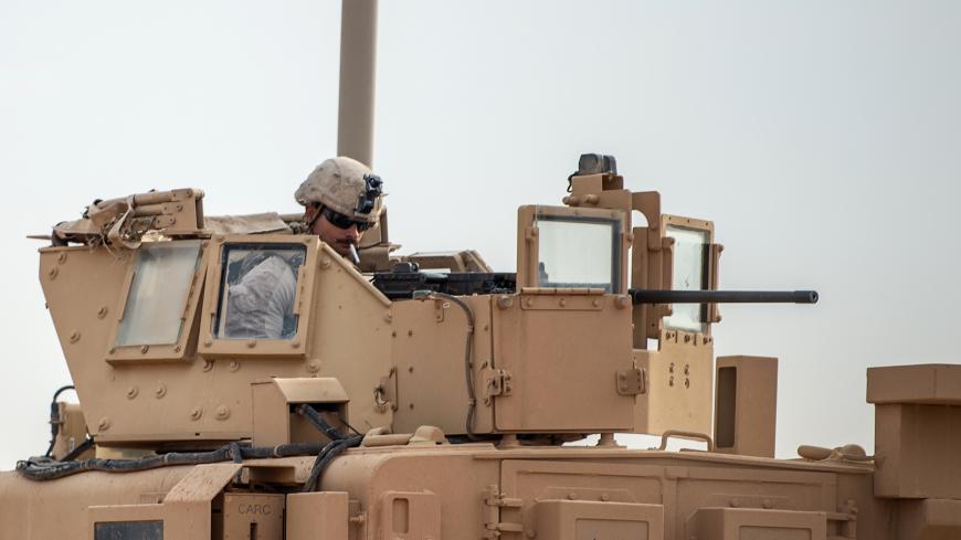 A picture taken on February 21, 2019 shows a US soldier atop an armoured vehicle on a road in Syria's northern Deir Ezzor province. - US-backed Syrian forces tried today to negotiate the release of civilians still trapped in the Islamic State group's last redoubt, as the international coalition warned the jihadists faced "inevitable defeat". (Photo by Bulent KILIC / AFP)        (Photo credit should read BULENT KILIC/AFP/Getty Images)