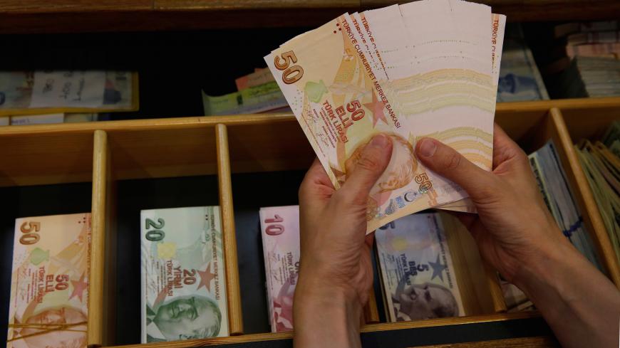 A money changer counts Turkish lira banknotes at a currency exchange office in Istanbul, Turkey August 13, 2018. REUTERS/Murad Sezer - RC139D2160B0
