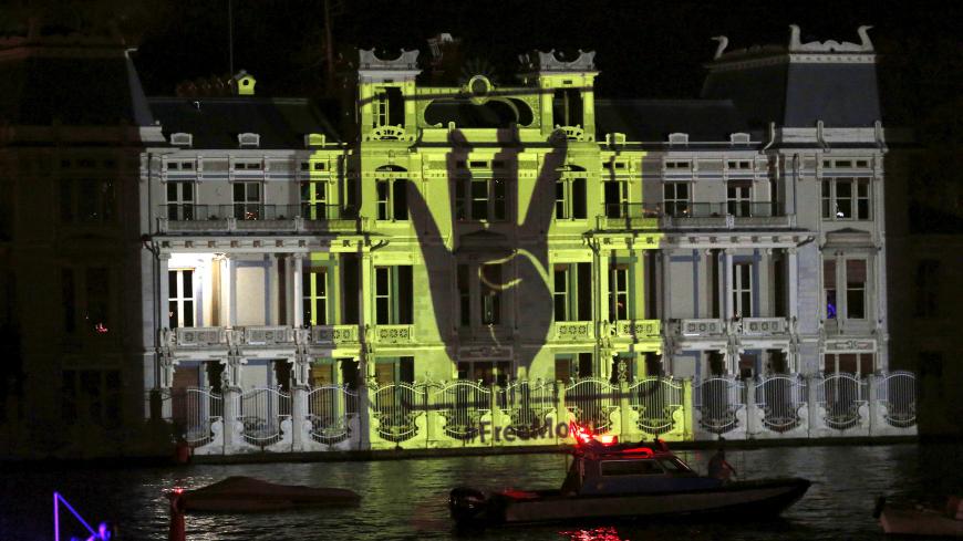 The Rabia sign is projected on the Egyptian Consulate during a protest against an Egyptian court's decision to sentence deposed President Mohamed Mursi to death, in Istanbul, Turkey, late June 16, 2015. REUTERS/Murad Sezer  - GF10000129868