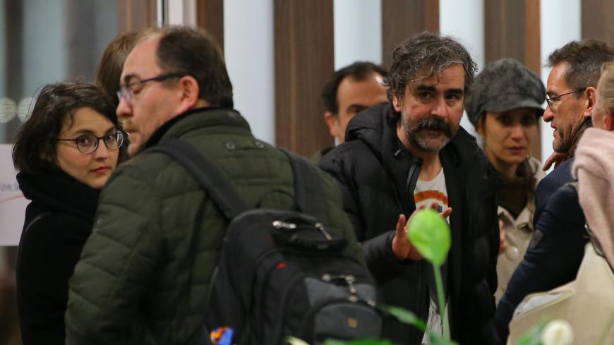 German-Turkish journalist Deniz Yucel walks through a plane as he is flanked by a group of people at Ataturk International Airport in Istanbul, Turkey, February 16, 2018. REUTERS/Huseyin Aldemir - UP1EE2G1ER906