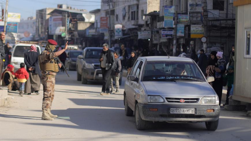 A member of Manbij Military Council gestures at a car in Manbij city, Syria December 29, 2018. Picture taken December 29, 2018. REUTERS/Rodi Said - RC1EFBFDDC70