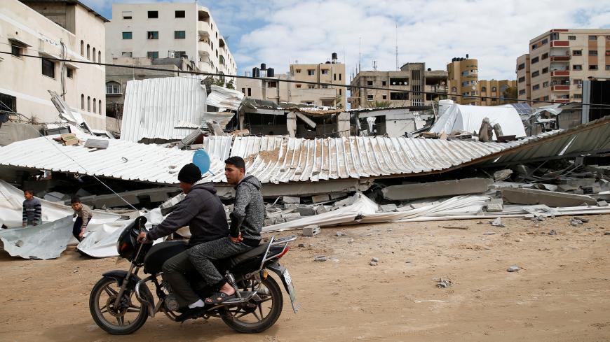 Palestinians pass near the destroyed Hamas site following Israeli air strikes, in Gaza City March 15, 2019. REUTERS/Mohammed Salem - RC1DEBFDC9E0