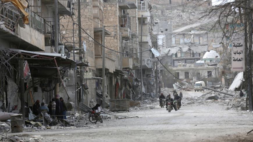 People ride motorcycles amidst the rubble of damaged buildings in the northern Syrian town of al-Bab, Syria, February 28, 2017. REUTERS/Khalil Ashawi - RC1680018E00