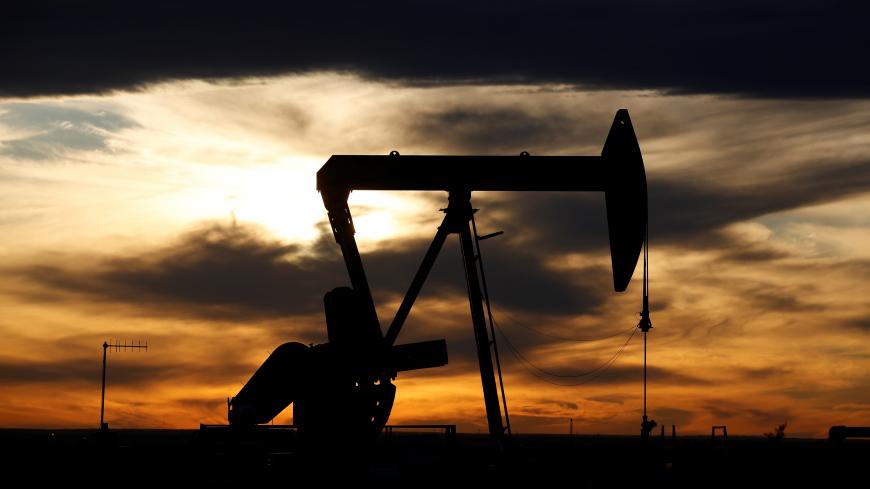 The sun sets behind a crude oil pump jack on a drill pad in the Permian Basin in Loving County, Texas, U.S. November 24, 2019. Picture taken November 24, 2019.  REUTERS/Angus Mordant - RC23NF9H59Z2