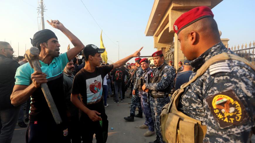 Police officers stand guard during an anti-government protest in front of the Governorate building in Basra, Iraq December 14, 2018. REUTERS/Essam al-Sudani - RC1FC42B5D70
