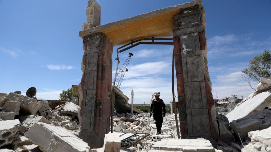 TOPSHOT - A member of the Syrian Civil Defence (White Helmets) inspects the rubble following shelling by Syrian regime forces and their allies on a the village of Maarit Sin in the countryside of the rebel-held Idlib province on May 11, 2019. (Photo by OMAR HAJ KADOUR / AFP)        (Photo credit should read OMAR HAJ KADOUR/AFP/Getty Images)