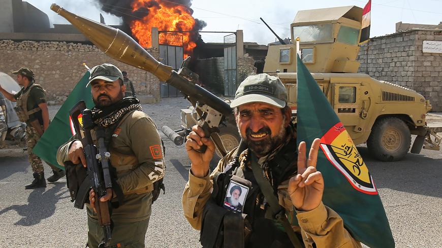 Fighters of Hashed Al-Shaabi (Popular Mobilization units) flash the victory gesture as they advance through a street in the town of Tal Afar, west of Mosul, after the Iraqi government announced the launch of the operation to retake it from Islamic State (IS) group control, on August 26, 2017. / AFP PHOTO / AHMAD AL-RUBAYE        (Photo credit should read AHMAD AL-RUBAYE/AFP/Getty Images)