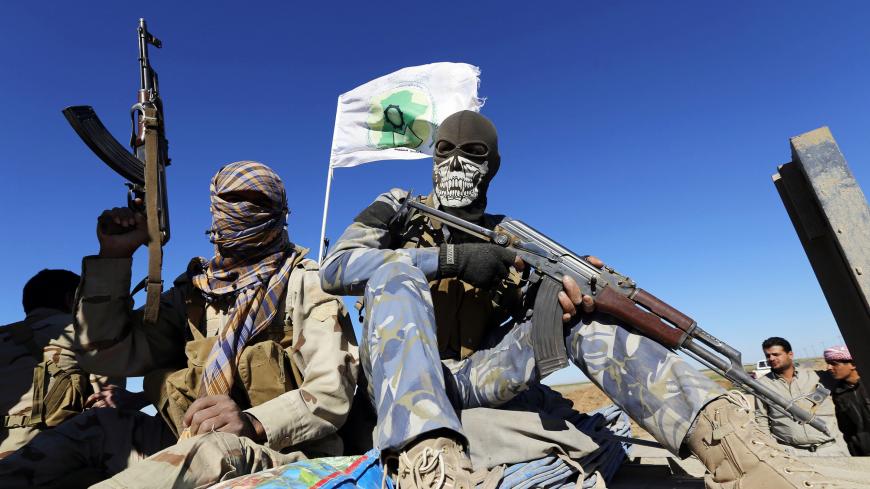 Masked Shi'ite fighters hold their weapons in Al Hadidiya, south of Tikrit, en route to the Islamic State-controlled al-Alam town, where they are preparing to launch an offensive on Saturday, March 6, 2015. Iraqi government forces and Iran-backed militiamen entered a town on the southern outskirts of Saddam Hussein's home city Tikrit on Friday, pressing on with the biggest offensive yet against Islamic State militants that seized the north last year. REUTERS/Thaier Al-Sudani (IRAQ - Tags: POLITICS CIVIL UNR