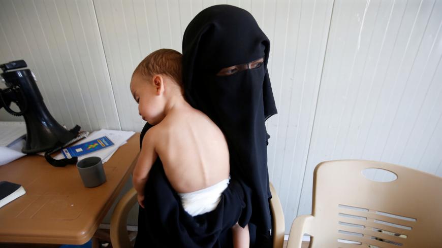 A foreign wife of Islamic State militants holds her child at Hammam Al-Alil camp in south of Mosul, Iraq September 13, 2017. Picture taken September 13, 2017. REUTERS/Azad Lashkari - RC1F166AB320