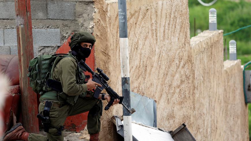 An Israeli soldier takes a position as forces search for a Palestinian gunman near Nablus, in the Israeli-occupied West Bank March 17, 2019. REUTERS/Mohamad Torokman - RC17DA0326D0