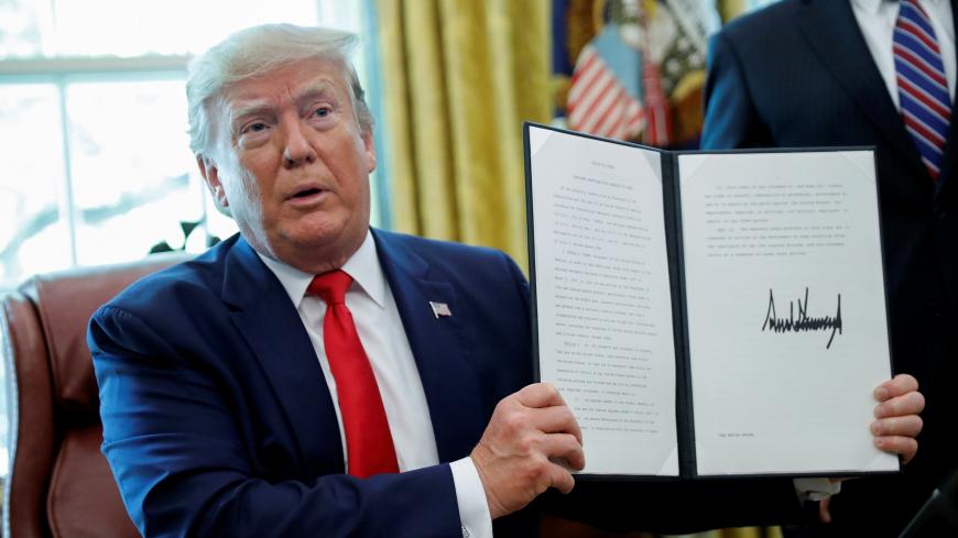 U.S.  President Donald Trump displays an executive order imposing fresh sanctions on Iran in the Oval Office of the White House in Washington, U.S., June 24, 2019. REUTERS/Carlos Barria - RC1310DB3000