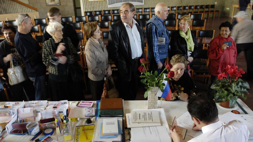 Israelis who immigrated from Russia wait in line at a polling station in the coastal city of Ashkelon December 2, 2007. Tens of thousands of Russian nationals living in Israel are expected to cast their ballots on Sunday for Russia's parliamentary election.  REUTERS/Amir Cohen (ISRAEL) - GM1DWSMXBJAA