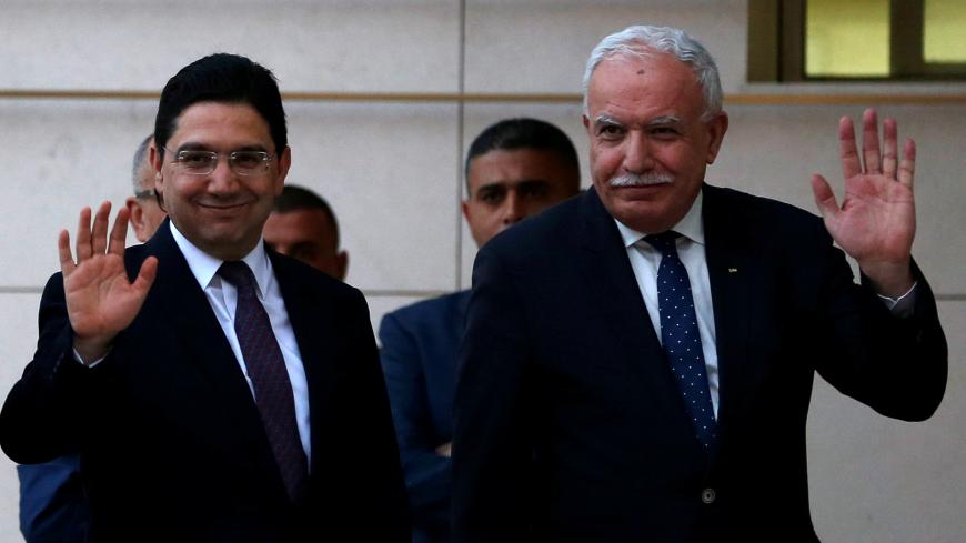 Moroccan Foreign Minister Nasser Bourita waves with Palestinian Foreign Minister Riyad Al Maliki upon his arrival in Ramallah, in the occupied West Bank March 27, 2018. REUTERS/Mohamad Torokman/Pool - RC1185BBFF50