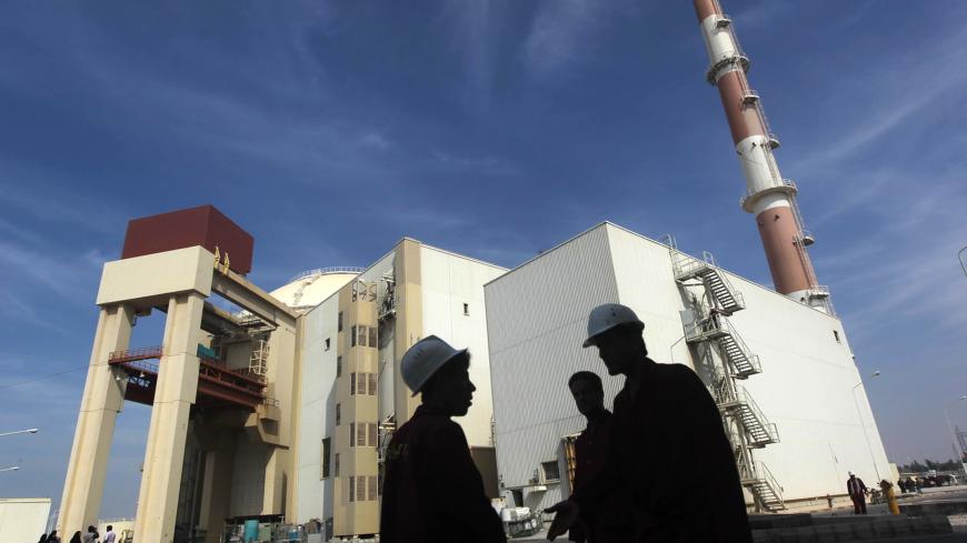 Iranian workers stand in front of the Bushehr nuclear power plant, about 1,200 km (746 miles) south of Tehran October 26, 2010. Iran has begun loading fuel into the core of its first nuclear power plant on Tuesday, one of the last steps to realising its stated goal of becoming a peaceful nuclear power, state-run Press TV reported on Tuesday. REUTERS/Mehr News Agency/Majid Asgaripour (IRAN - Tags: POLITICS ENERGY IMAGES OF THE DAY) - GM1E6AQ1G1401