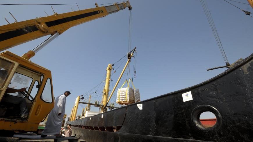 Workers unload supplies from the Libyan-chartered ship Amalthea, which was carrying aid for Palestinians in Gaza, in El Arish port, 344 km (214 miles) northeast of Cairo July 15, 2010. The ship reached the Egyptian port on Wednesday after altering its course following a warning from Israel's navy not to head to the blockaded Gaza Strip. REUTERS/Mohamed Abd El-Ghany (EGYPT - Tags: CIVIL UNREST POLITICS) - GM1E67G042101