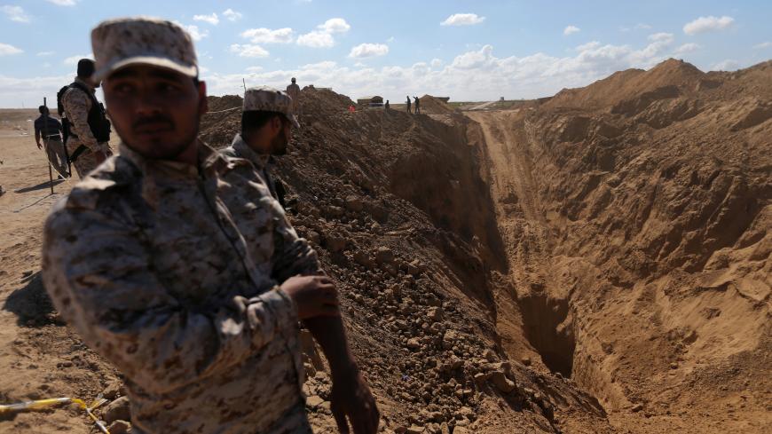 Members of Palestinian security forces loyal to Hamas stand while searching for missing or dead militants after Israel blew up a cross-border tunnel, in Khan Younis in the southern Gaza Strip November 3, 2017. Picture taken November 3, 2017. REUTERS/Ibraheem Abu Mustafa - RC13FEDDA970