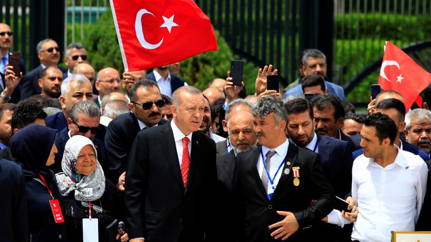 Turkish President Tayyip Erdogan visits a monument as he is flanked by his supporters during a ceremony marking the third anniversary of the attempted coup, at the Presidential Palace in Ankara, Turkey, July 15, 2019. REUTERS/Umit Bektas - RC11458C43B0