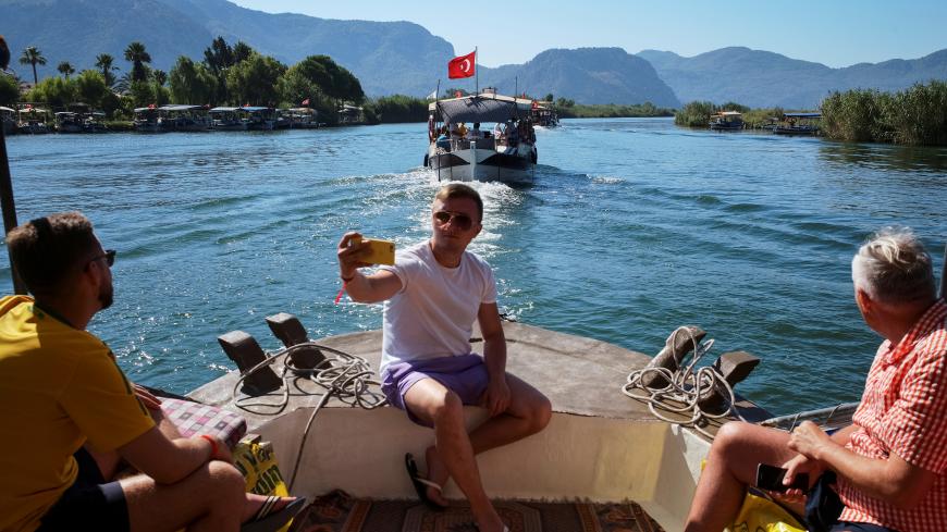 Tourists ride at a local cruise boat on the Dalyan river to Iztuzu Beach near Dalyan in Mugla province, Turkey August 12, 2019. Picture taken August 12, 2019.  REUTERS/Gleb Garanich - RC1E13E68240