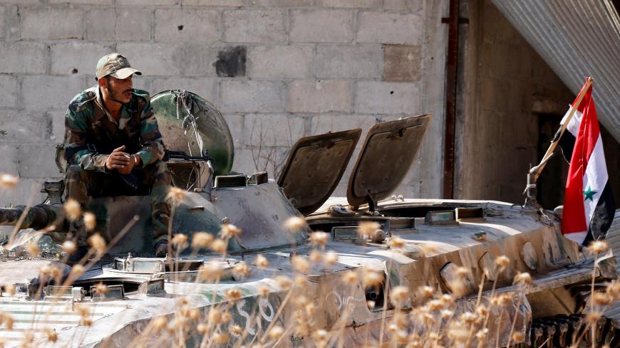A Syrian army soldier smokes cigarette as he sits on a military vehicle in Khan Sheikhoun, Idlib, Syria August 24, 2019. REUTERS/Omar Sanadiki - RC13C4D5FE50