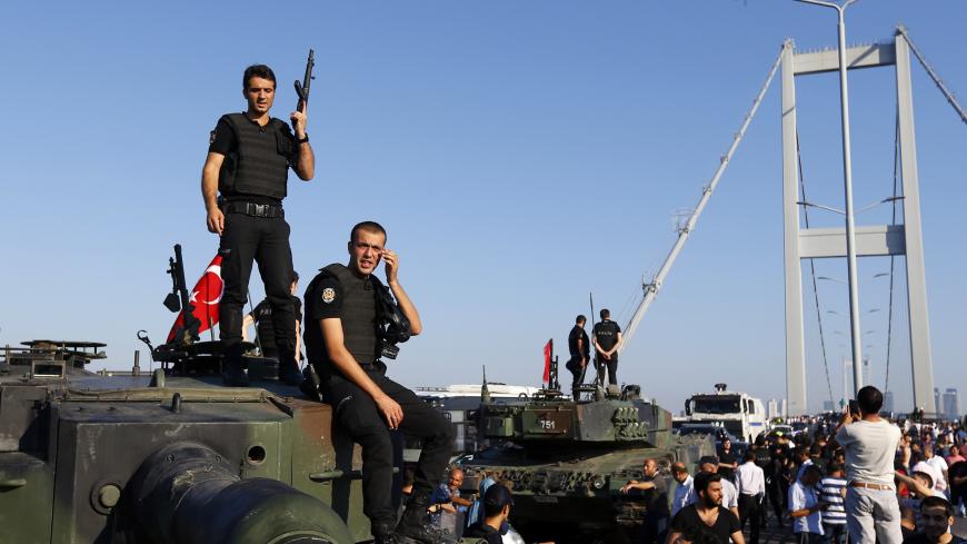 Policemen stand atop military armored vehicles after troops involved in the coup surrendered on the Bosphorus Bridge in Istanbul, Turkey July 16, 2016. REUTERS/Murad Sezer - LR1EC7G0KXRL2