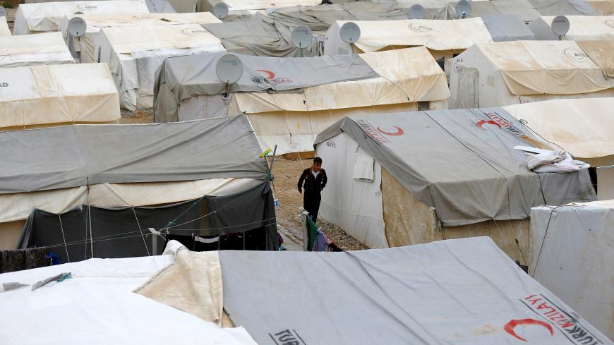 A Syrian refugee man walks between tents in Nizip refugee camp, near the Turkish-Syrian border in Gaziantep province, Turkey, November 30, 2016. REUTERS/Umit Bektas - RC1D41DB2700