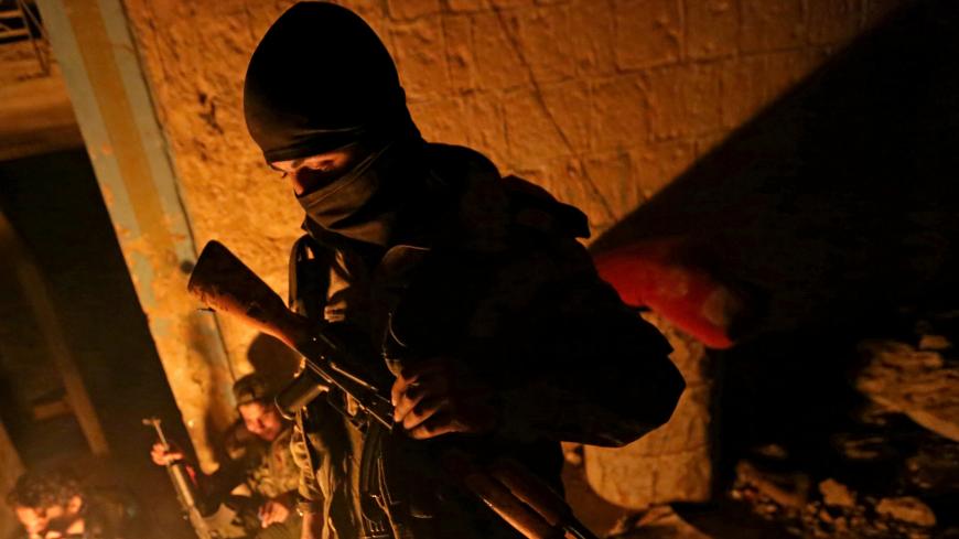Turkey-backed Free Syrian Army fighter holds a weapon in the town of Tadef in Aleppo Governorate, Syria February 12, 2018. Picture taken February 12, 2018. REUTERS/Khalil Ashawi - RC1182F48C20