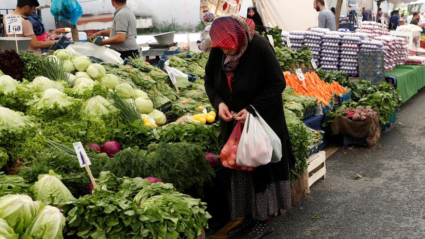 A woman counts her money as she shops at a bazaar in Istanbul, Turkey, May 29, 2019. REUTERS/Murad Sezer - RC13E49E1B00