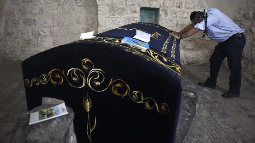 A Jewish worshipper policeman prays in Joseph's Tomb in the West Bank city of Nablus early July 4, 2011. Israeli troops escorted buses with Jewish worshippers to the tomb in coordination with the Palestinian forces that control Nablus to let Jews pray on the day when it is believed Joseph died, at the site believed to be the burial place of the biblical patriarch Joseph. REUTERS/Nir Elias (WEST BANK - Tags: POLITICS RELIGION CIVIL UNREST) - GM1E7740WG601