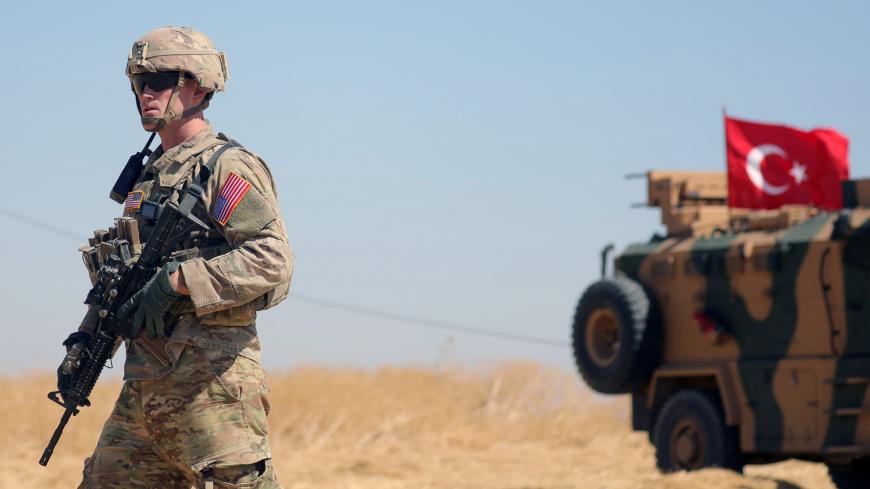 An American soldier walks near a Turkish military vehicle during a joint U.S.-Turkey patrol, near Tel Abyad, Syria September 8, 2019. REUTERS/Rodi Said - RC197A15DCF0